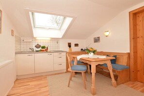 Een keuken met dakraam, houten eettafel en stoelen.