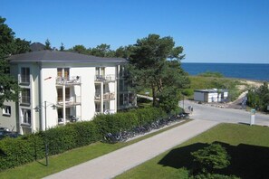 A multi-story building with balconies, a pathway, and a view of the sea. - Holiday apartment with 1 bedroom (Heringsdorf)