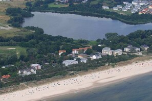 An aerial view of a coastal area with a beach, a lake, and residential buildings. - Holiday apartment with 1 bedroom (Heringsdorf)