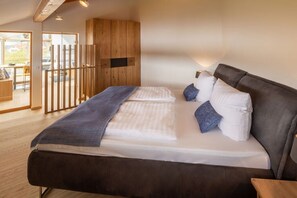 A bedroom with a large bed, wooden wardrobe, and a view to an outdoor area. - Holiday apartment in Kronburg with sauna (Kronburg)
