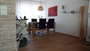 Un comedor con mesa, sillas y una lámpara colgante.