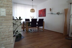 Ein Essbereich mit Tisch, Stühlen und einer Hängelampe.
