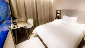 A hotel room with a bed, a desk, a chair, a television, and curtains. - Hanting Hotel Shanghai Dapuqiao Ruijin Nan Road (Shanghai)
