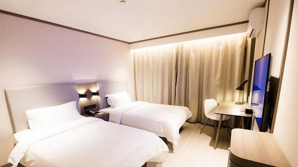 A hotel room with two beds, a desk, a chair, a TV, and a waste bin. - Hanting Hotel Shanghai Dapuqiao Ruijin Nan Road (Shanghai)