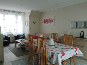 Un salon chaleureux avec une table à manger, des chaises, un canapé et une table basse.