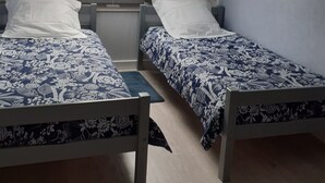 A dormitory room with two single beds, a small desk, a window, and a ceiling fan. - Dinard-ville location 2 chambres, plage de l'écluse-commerces-transports à pieds (Dinard)