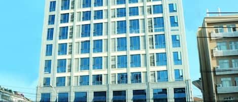 Een hotelgebouw met meerdere verdiepingen, een modern gevelontwerp en grote ramen.