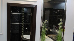 A hotel entrance with a dark wooden door, a glass panel, and a small potted plant with white flowers. - Lailaty Hotel Apart (Riyadh)