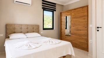 Une chambre à coucher avec un lit, un appareil de climatisation, une fenêtre donnant sur un beau paysage et une porte en bois.