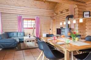 A log cabin interior with a dining area, sofa, and a fireplace. - Holiday home in Schierke with sauna (Schierke)