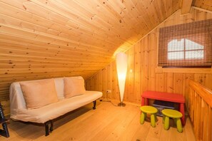A cozy room with a wooden ceiling, a sofa, a table with stools, and a window with blinds. - Holiday home in Schierke with sauna (Schierke)