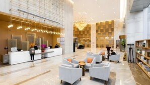 A spacious lobby with a reception desk, seating area, and a large chandelier. - Guohui Hotel (Fuzhou)