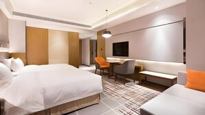 A modern hotel room with a large bed, a desk, a sofa, and a TV. - Guohui Hotel (Fuzhou)