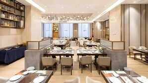 A spacious restaurant with multiple dining tables and chairs, a bar area with shelves, and a modern ceiling design. - Guohui Hotel (Fuzhou)