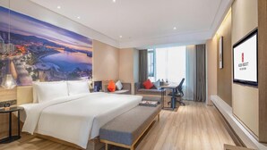A hotel room with a large bed, a desk, a chair, a view of the cityscape, and a mounted screen displaying hotel information. - Rezen Select Hangzhou Xiaoshan Airport (Hangzhou)