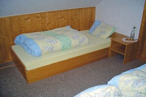 A single bed with a wooden headboard and a bedside table with a lamp. - Holiday home in Stützerbach with Wi-Fi (Stützerbach)