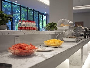 A buffet setup with various food items and beverages. - Yuhuayuan Design Hotel (Haikou)