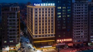 A multi-story hotel with a prominent sign, surrounded by other buildings. - Kyriad Marvelous Hotel (Dongguan)