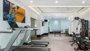 A gym with treadmills, weight machines, and a poster on the wall. - Kyriad Marvelous Hotel (Dongguan)