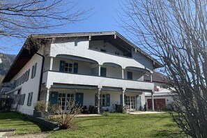 Un edificio a due piani con un balcone al piano superiore, un portico e un garage.