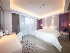 A hotel room with a bed, bedside table, lamp, and a window with curtains. - Lavande (Beijing)