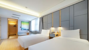 A hotel room with two beds, a seating area, a desk, and a large window. - Lavande (Beijing)