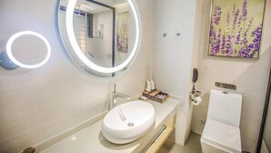 A modern bathroom with a round mirror, a white sink, and a toilet. - Greentree Inn Zhuma Railway Station Qian Plaza Branch (Zhumadian)