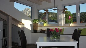 A dining area with a table, chairs, and potted plants. - "Penthouse" Alpine Bliss (Füssen)