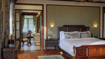 A traditional bedroom with a wooden bed, two bedside lamps, a nightstand, a dresser, and a mirror.