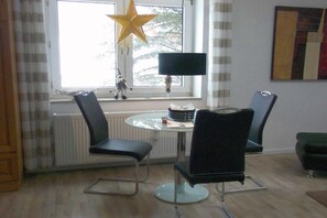 Un'area pranzo con un tavolo rotondo, due sedie, una decorazione a stella, una lampada e un termosifone.