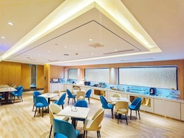 Restaurante moderno com balcão comprido e cadeiras azuis.