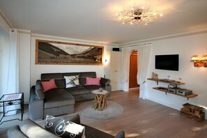 A modern living room with a sofa, a coffee table, and a painting on the wall. - Holiday apartment with 1 bedroom (Oberstdorf)