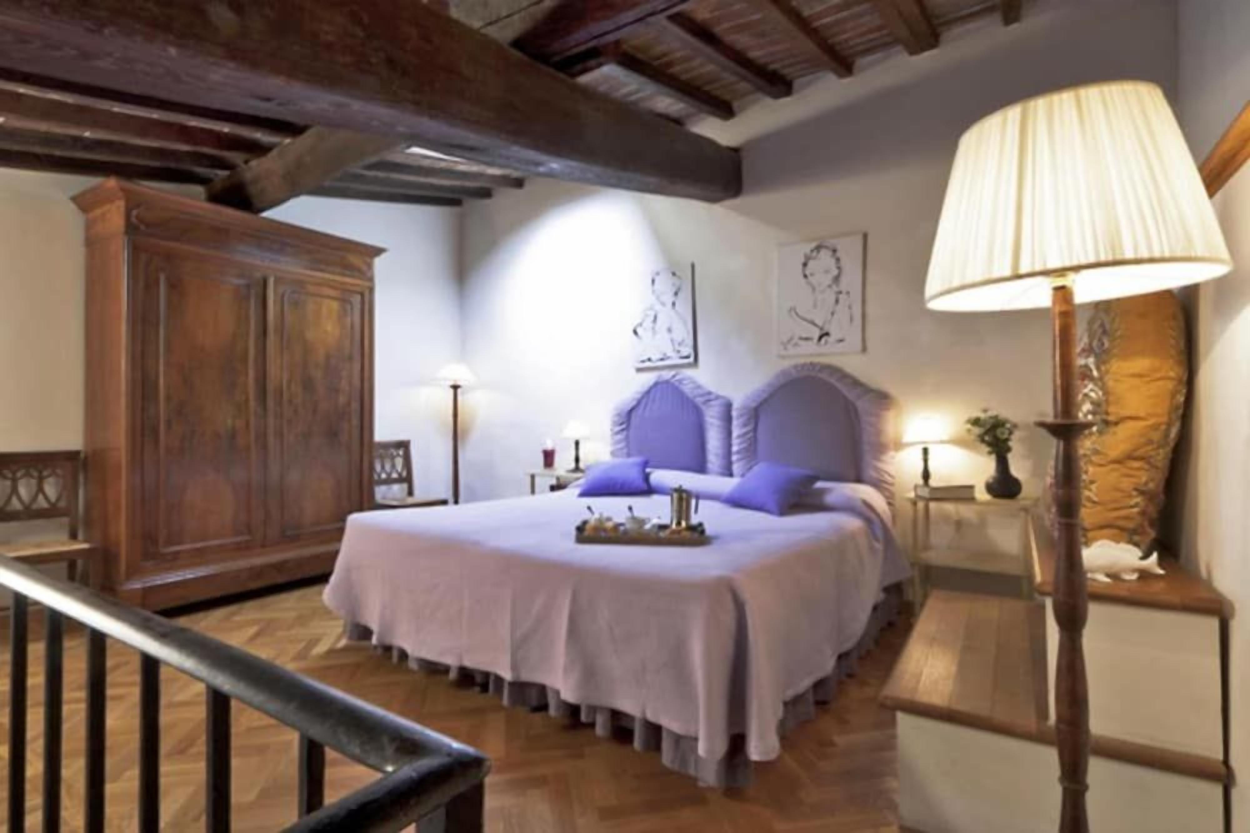 A bedroom with a bed, wooden furniture, and a lamp.