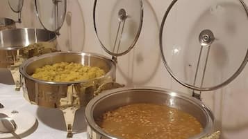 A buffet table with various food containers and serving utensils.