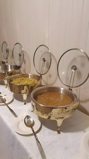 A buffet table with various food containers and serving utensils. - Burj ul Zaki (Islamabad)