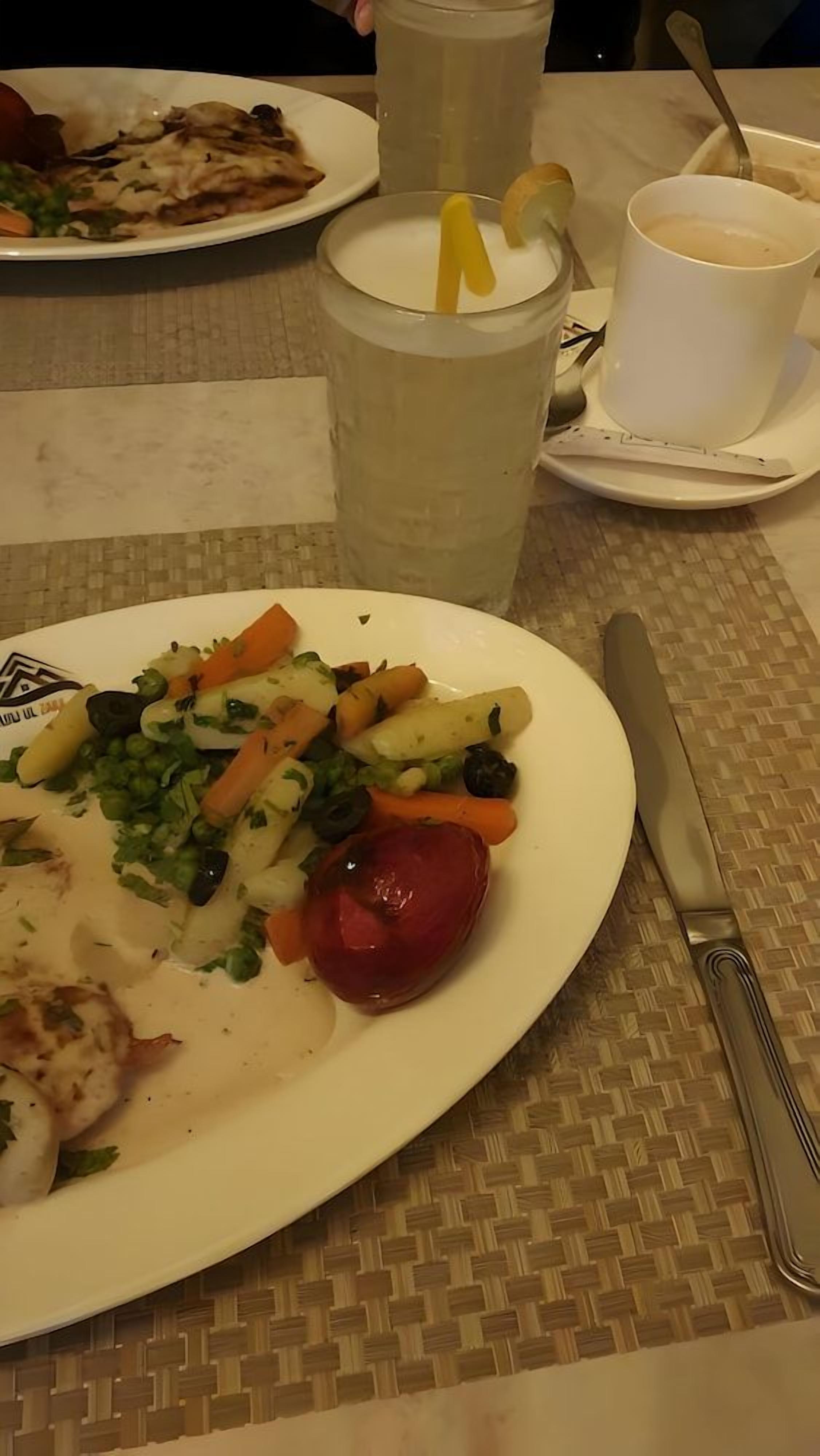 Ein Esstisch mit Essen, einer Kaffeetasse und einer Kerze.
