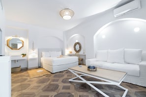 A modern, white-themed living room with a sofa, a coffee table, and a bed with a headboard. - The Well Parga (Parga)