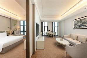 A hotel room with a bed, a desk, a sofa, a dining table, and a large window. - Holiday Inn Jianhu (Yancheng)