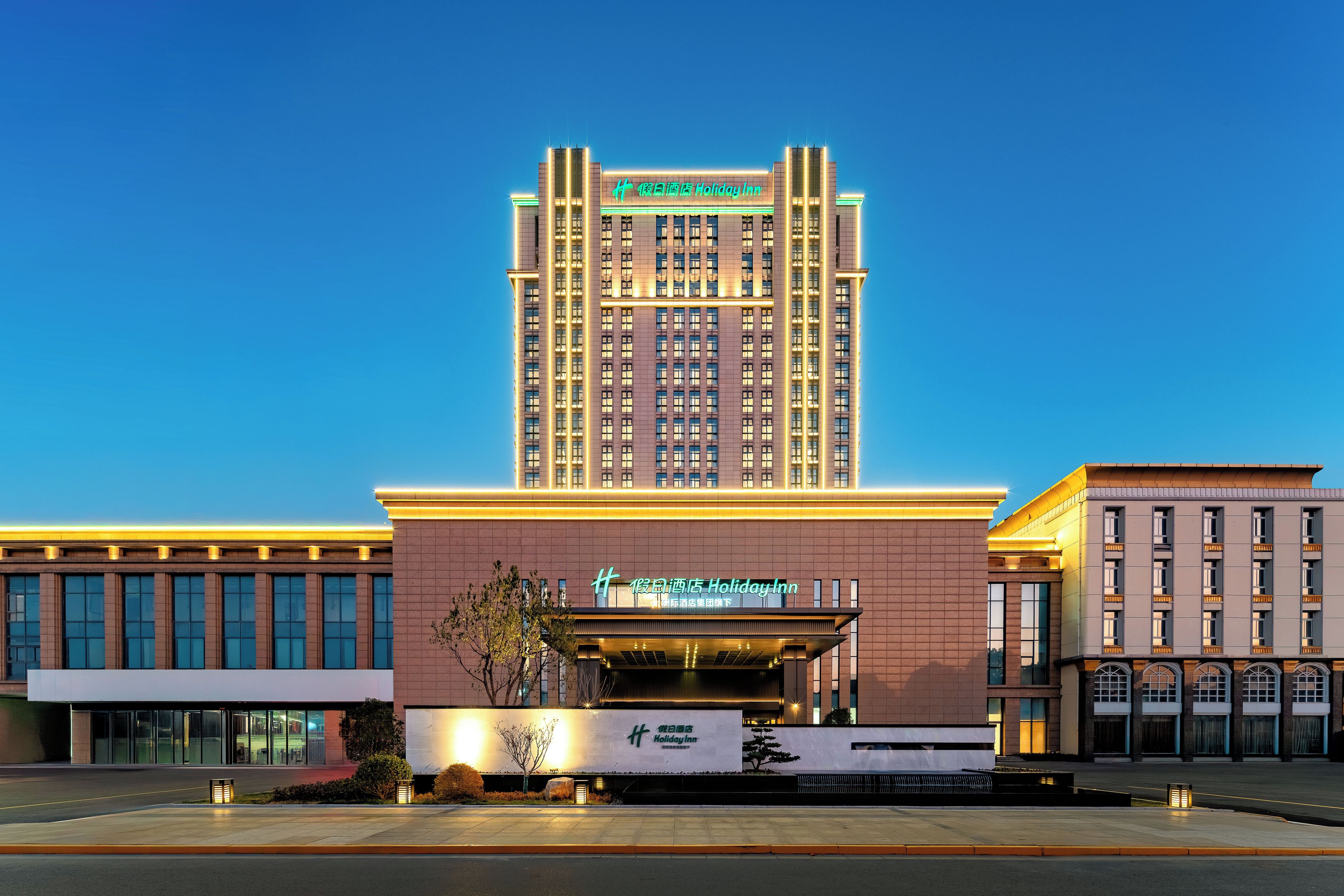 A Holiday Inn hotel with a prominent tower and a modern building facade.
