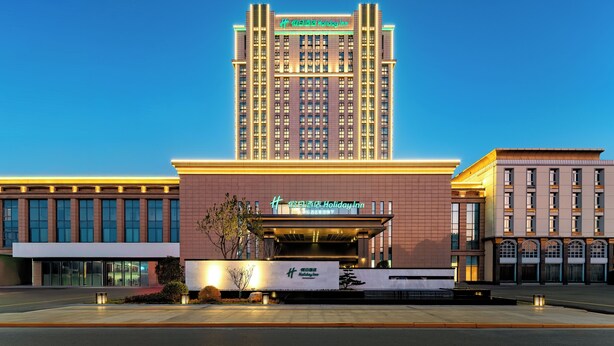 A Holiday Inn hotel with a prominent tower and a modern building facade. - Holiday Inn Jianhu (Yancheng)