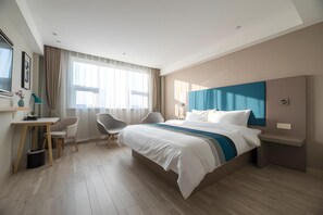 A hotel room with a large bed, a desk, two chairs, and a window with curtains. - Homeinn Selected (Wuxi)