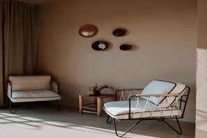 A room with two chairs, a small table with a vase, and wall-mounted decorative plates. - Hotel Auberge La Feniere (Cadenet)