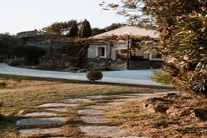 A stone pathway leading to a house with a garden and a large pot in the foreground. - Hotel Auberge La Feniere (Cadenet)