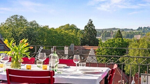Un espace de restauration en plein air avec des tables disposées pour deux personnes, offrant une vue sur un paysage pittoresque.