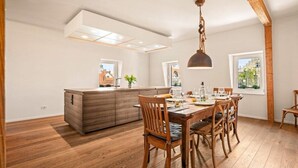 Un coin repas avec une table en bois, des chaises et un luminaire suspendu.