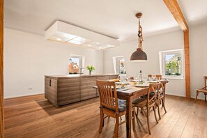 Un coin repas avec une table en bois, des chaises et un luminaire suspendu.