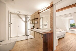 Une salle de bain moderne avec une douche à l’italienne en verre, un grand miroir et un meuble-lavabo en bois.