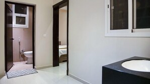 Et badeværelse med toilet, bruser og håndvask.
