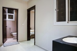 A bathroom with a toilet, a shower, and a sink. - OYO 628 Wasan Suites (Riyadh)