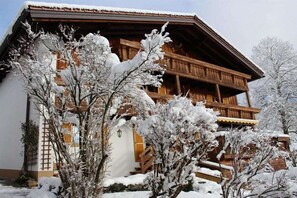A wooden chalet with a balcony, surrounded by snow-covered trees. - Hefle in the Gottstein House (Bad Hindelang)